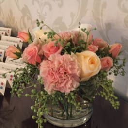 Pink and cream rose bouquet in a clear glass bowl vase