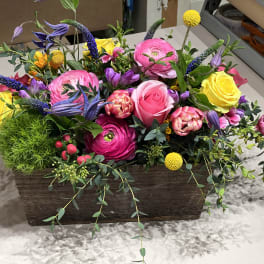 Colorful mixed flower arrangement in a rectangular wooden container