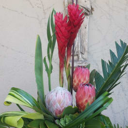 Tropical floral arrangement with red protea and pink blooms