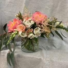 Pink and peach floral arrangement in a clear glass vase