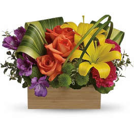 Orange roses and yellow lilies in a wooden box with purple accents