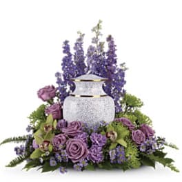 Purple floral arrangement around a white urn