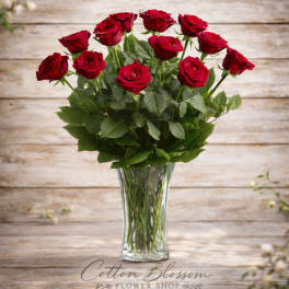 Red roses arranged in a clear glass vase
