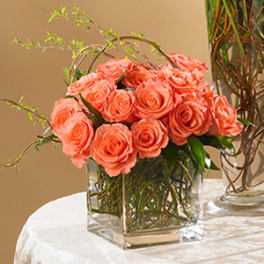 Coral rose bouquet in a clear square vase