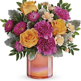 Mixed bouquet of yellow roses, purple carnations and mums in a gradient orange glass cylinder vase