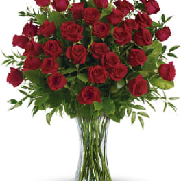 Red roses arranged in a clear glass vase