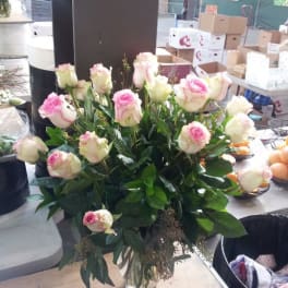Pink and white roses arranged in a clear glass vase