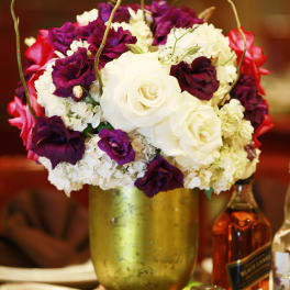 White and purple rose arrangement in a gold vase