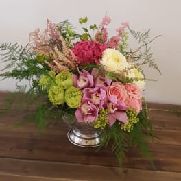 Mixed bouquet in a silver vase with pink, green, and white flowers