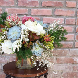 Mixed bouquet with succulents and white flowers in a glass vase
