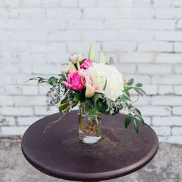 Pink and white floral arrangement in a clear glass vase