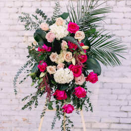 Tall floral spray with pink and cream roses on an easel