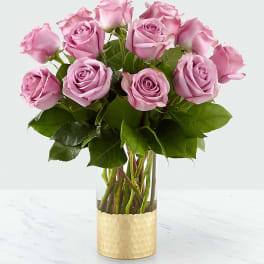 Pink roses arranged in a gold-textured vase