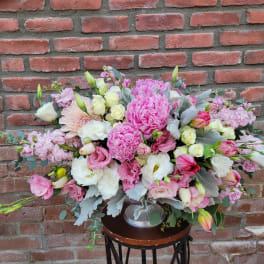 Large pink and white floral arrangement in a silver vase