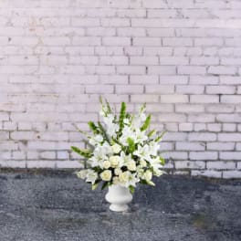 White floral arrangement in a white pedestal vase