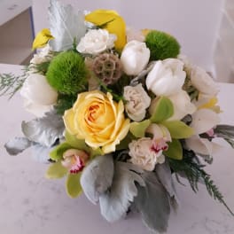 Bouquet of yellow and white flowers with green pom-pom accents