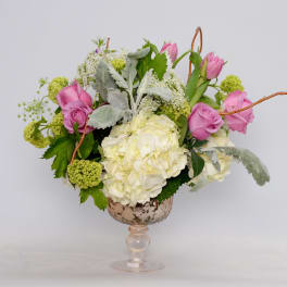 Pink roses and white hydrangea in a glass pedestal vase