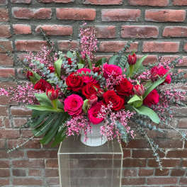 Pink and red rose arrangement in a white vase