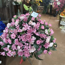 Large pink floral arrangement with roses and lilies in a shop display