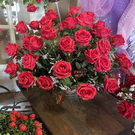 Large bouquet of bright red roses with purple mesh decor