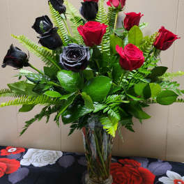 Bouquet of red and black roses in a clear glass vase
