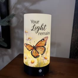Cylindrical memorial candle with a butterfly and daisies