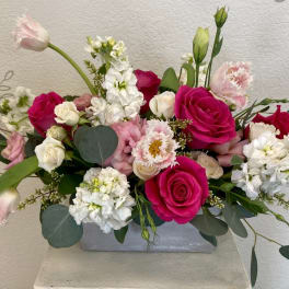 Pink and white rose arrangement in a gray rectangular vase