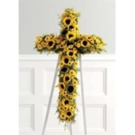 Cross-shaped sunflower funeral spray on a stand