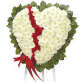 Heart-shaped white floral tribute with a red ribbon and green border