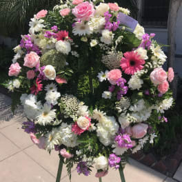 Large standing floral wreath with pink, white, and purple blooms