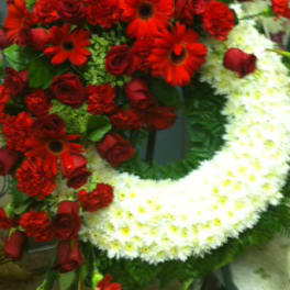 Red floral funeral wreath with white accent flowers