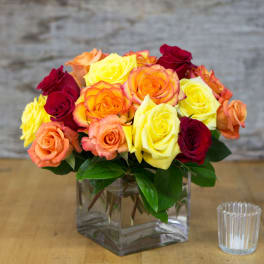 Bouquet of multicolored roses in a clear square vase