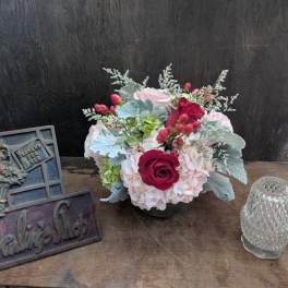 Arrangement of pink hydrangeas and red roses in a low vase