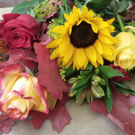 Bouquet with sunflowers, roses, and autumn leaves