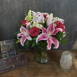 Bouquet of pink lilies and red roses in a glass vase
