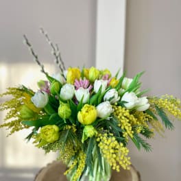 Bouquet of white, yellow, and pink tulips in a glass vase