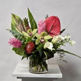Tropical bouquet in a glass vase with pink and white blooms