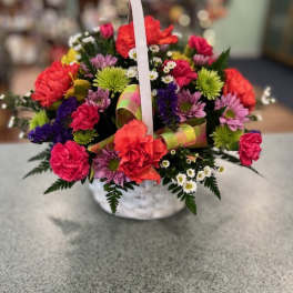 Colorful mixed flower basket with a white handle