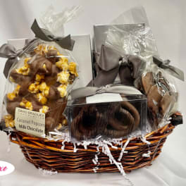 Gift basket with wrapped chocolates and caramel popcorn in a wicker basket