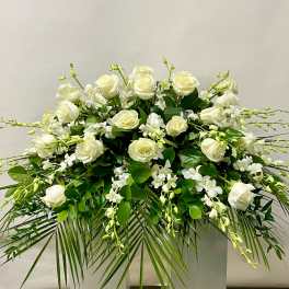 White roses and orchids arranged in a large floral display