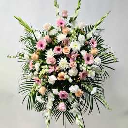 Large standing floral spray with pink and white flowers and palm fronds