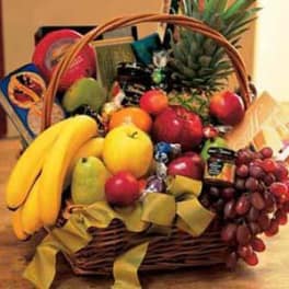 Fruit basket with bananas, apples, grapes, and packaged snacks