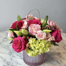 Pink roses and pale green hydrangea in a pink vase