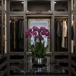 Pink orchids in a silver bowl on a black marble table