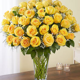 Yellow roses arranged in a clear glass vase on a table