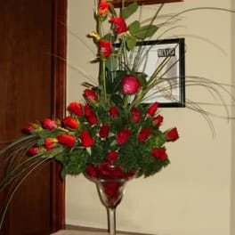 Tall red rose arrangement in a clear stemmed vase