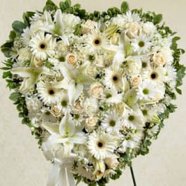 Heart-shaped white floral arrangement with lilies and daisies