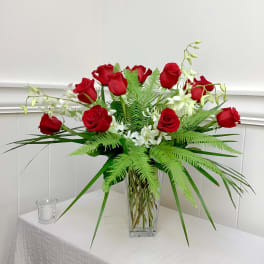 Red roses and white orchids in a clear glass vase