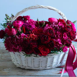 Basket of red and pink roses with hydrangeas and ribbon