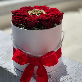 Round box of red roses with a red ribbon bow